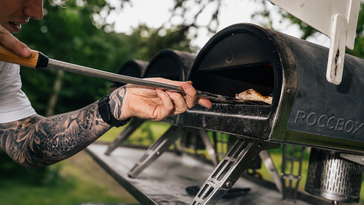 A Pizza Club chef firing pizza in a portable oven at a private party