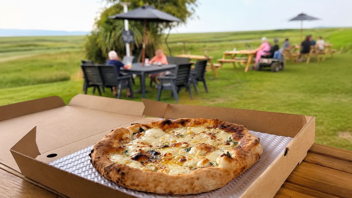 Fresh wood-fired pizza served in a pub garden overlooking open countryside