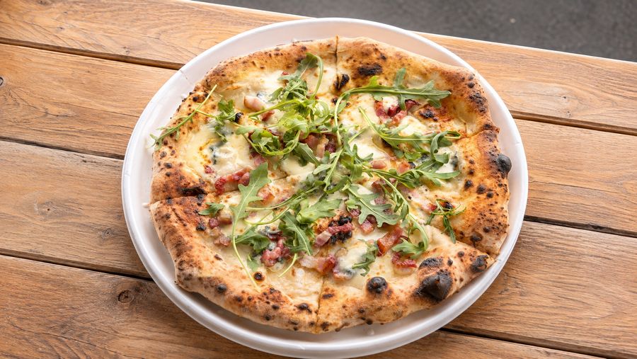 Wood-fired white pizza topped with rocket and pancetta