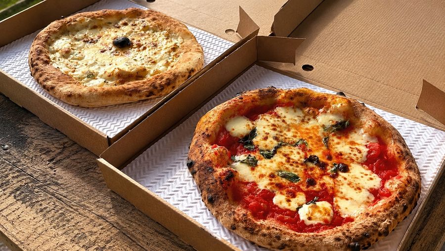Two different wood-fired pizzas ready to share