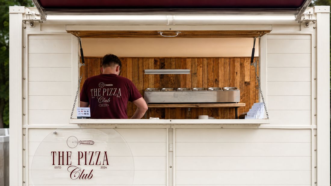 The Pizza Club trailer set for service with Tom working inside